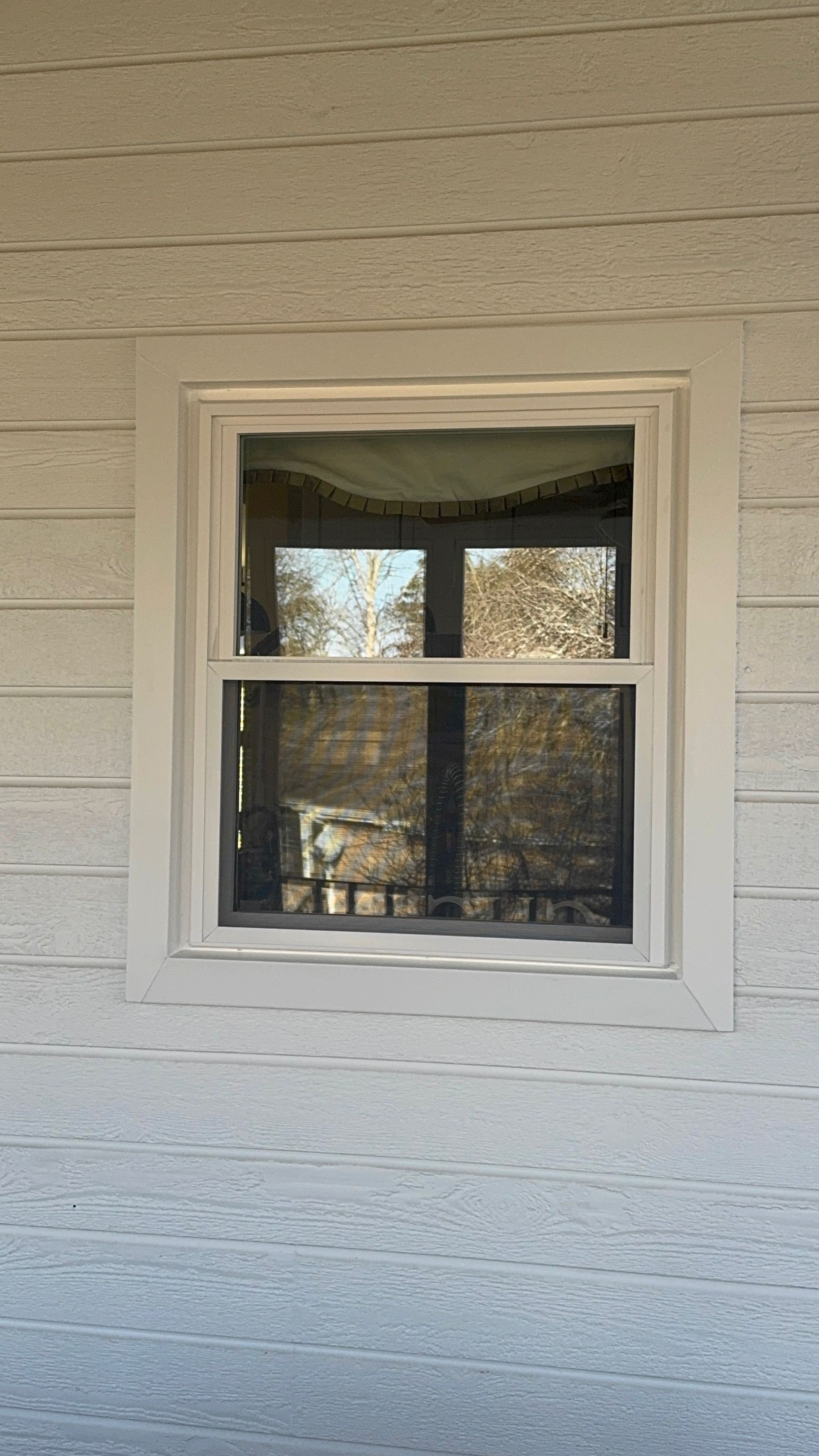A white house with a window on the side of it.