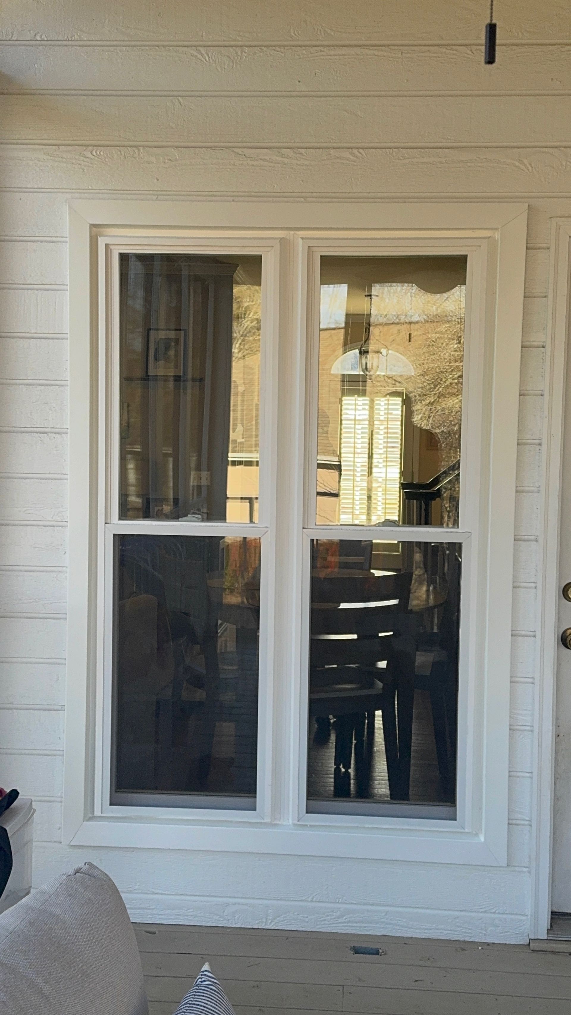 A white house with a large window and a door.