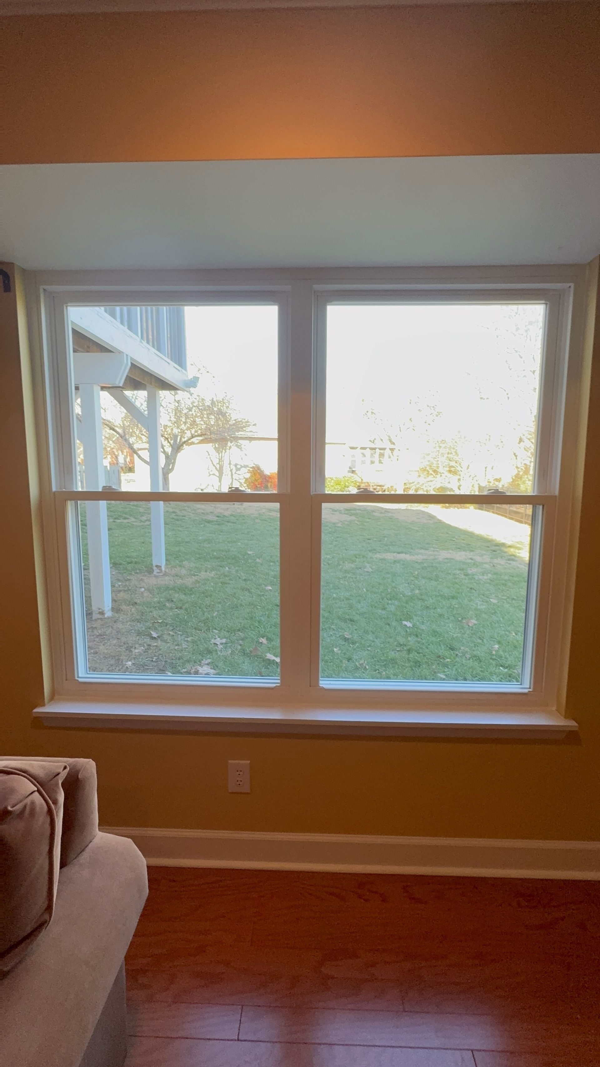 A living room with a large window and a couch.