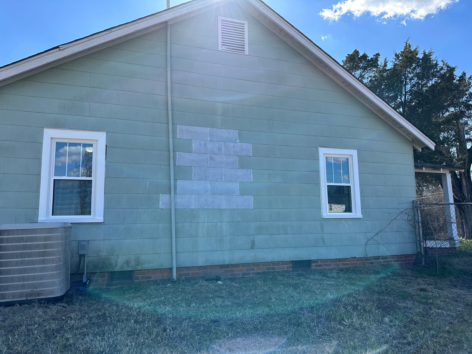 A house with a lot of windows and a fan on the side of it.
