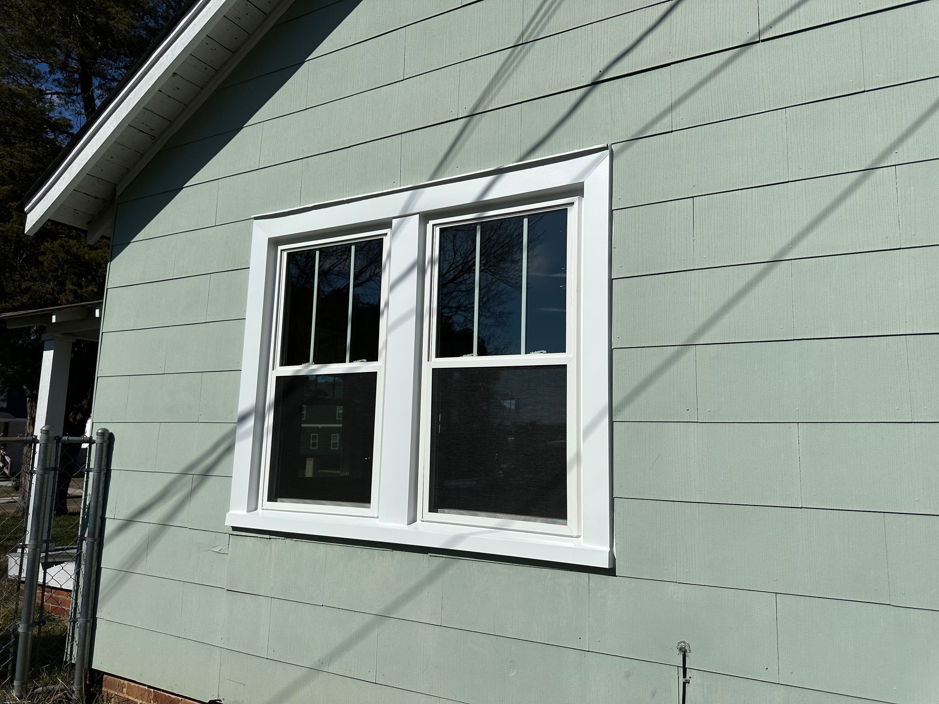 A house with two windows on the side of it
