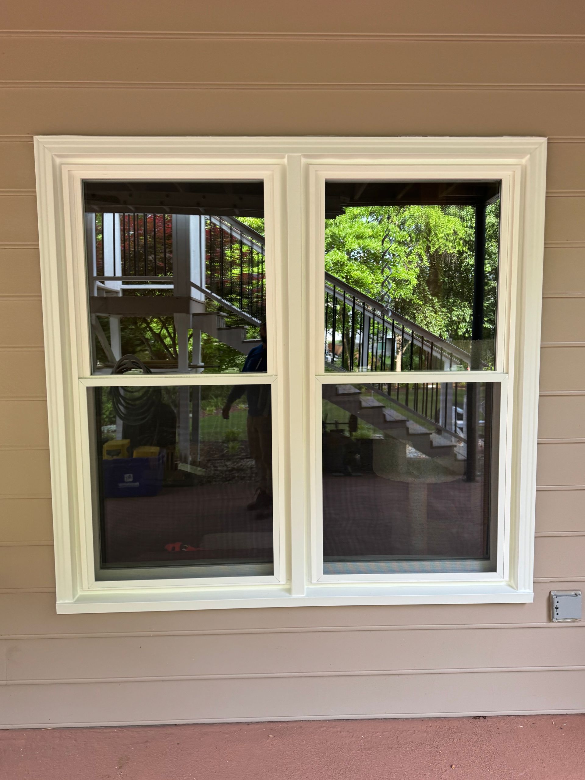A window on the side of a house with a view of a porch.