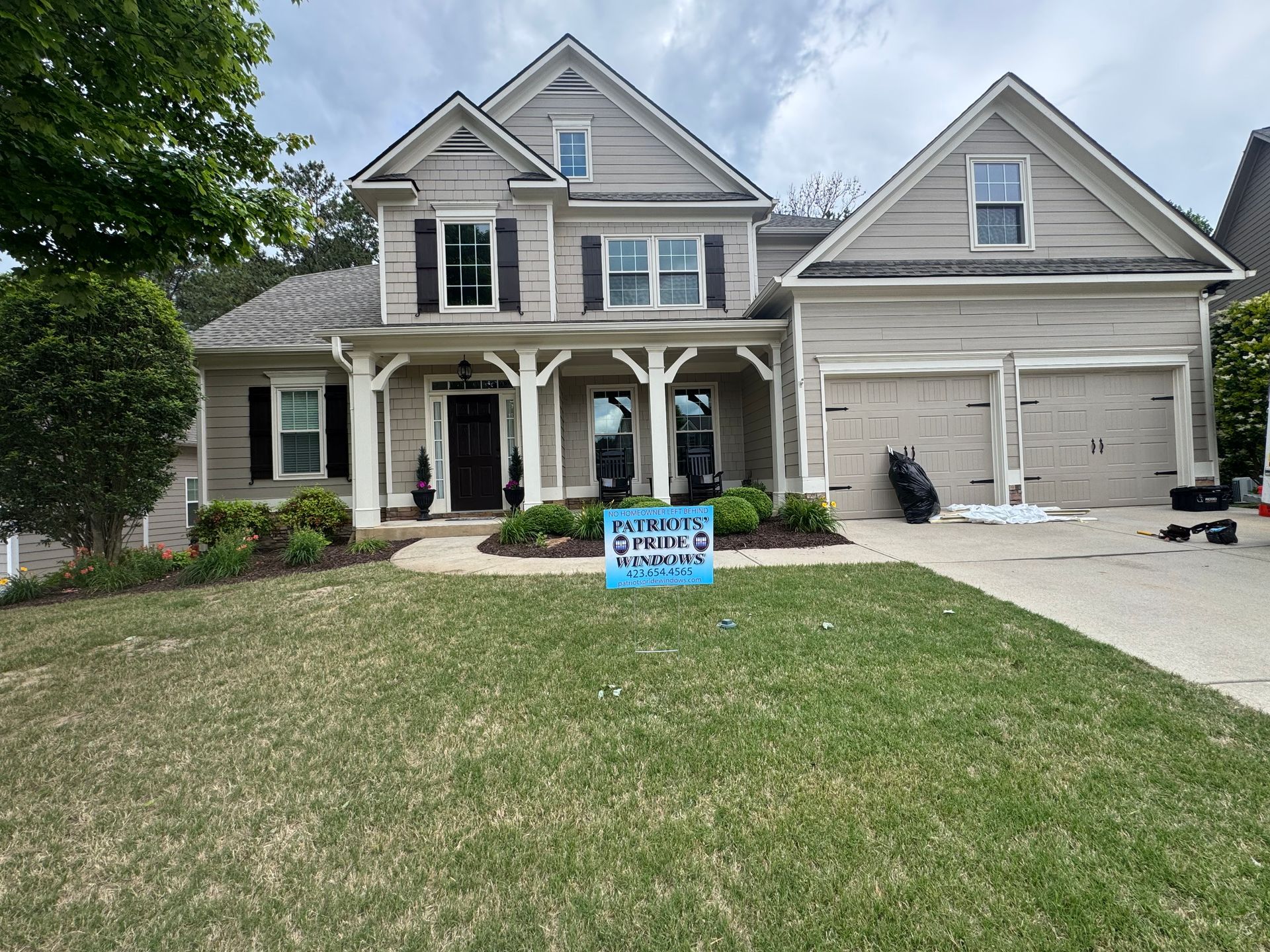 A large house with a blue sign in front of it.