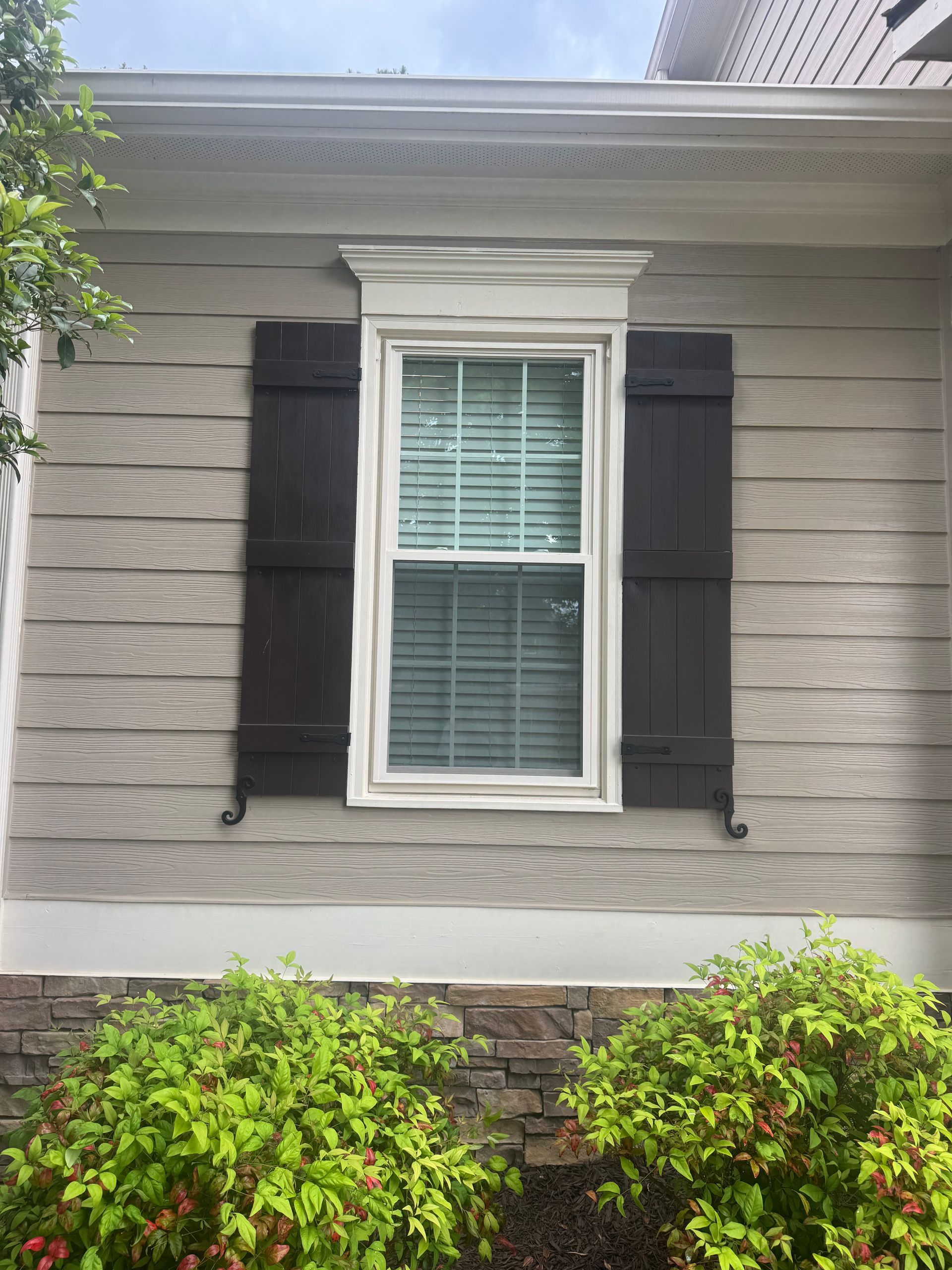 A house with a window and black shutters on it.