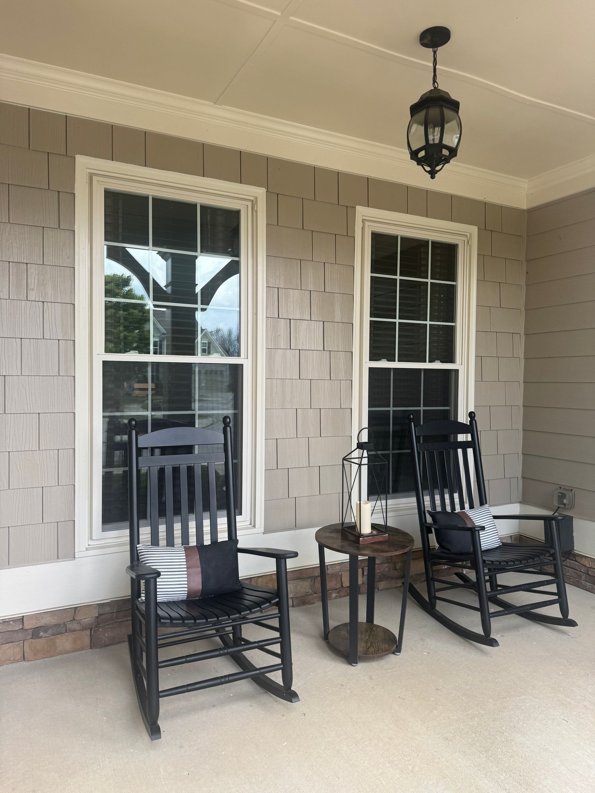 A porch with two rocking chairs and a table