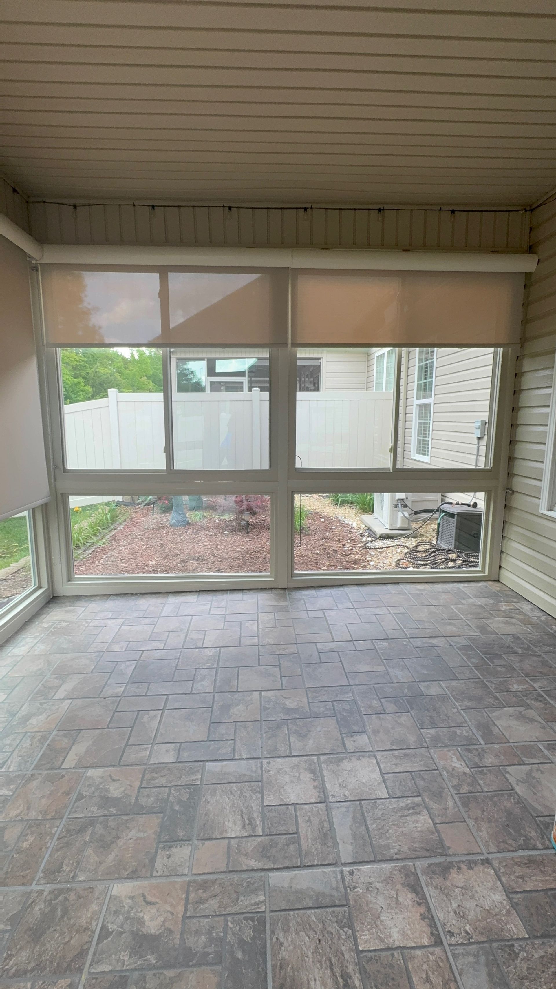 An empty room with a lot of windows and a tiled floor.