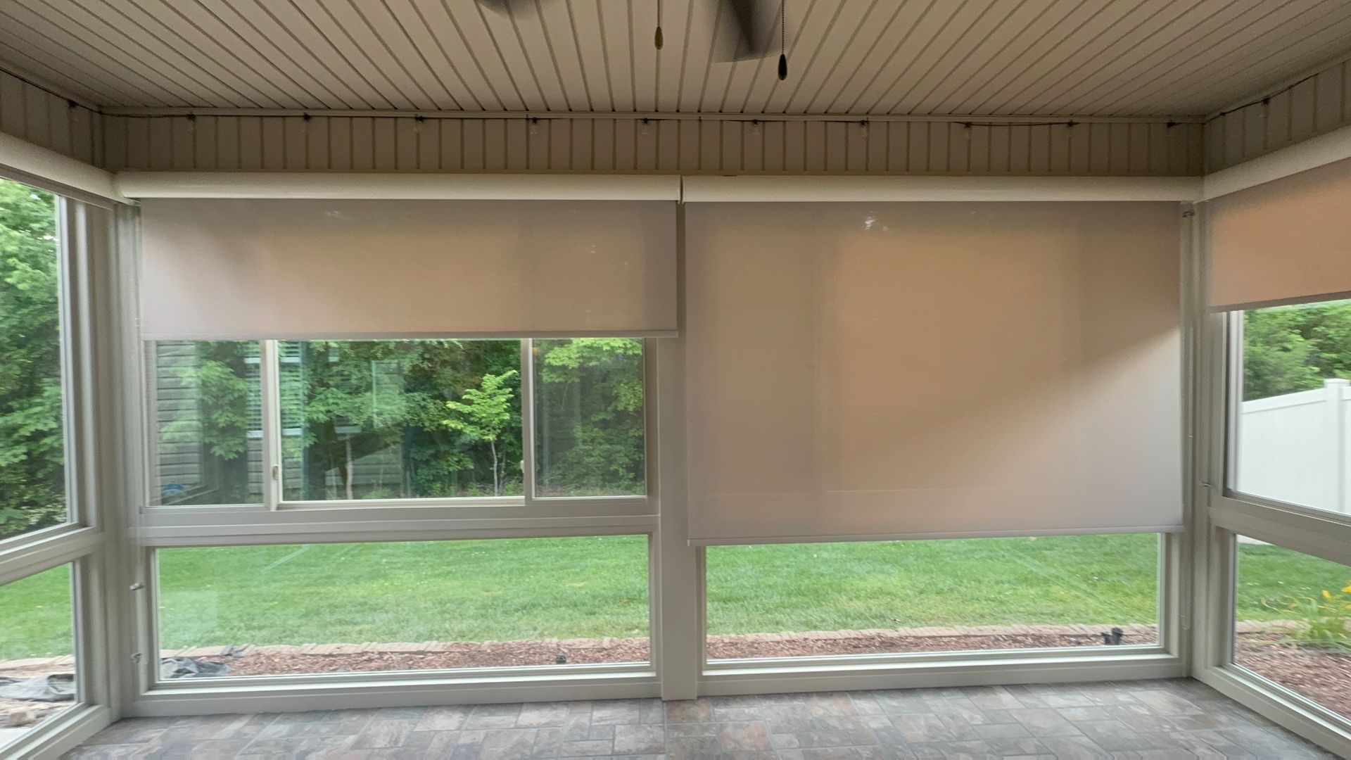 A screened in porch with lots of windows and blinds.