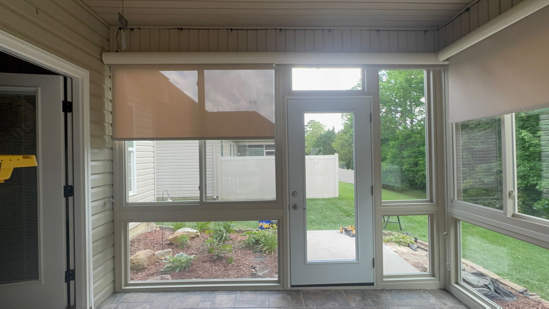 A screened in porch with lots of windows and a door.