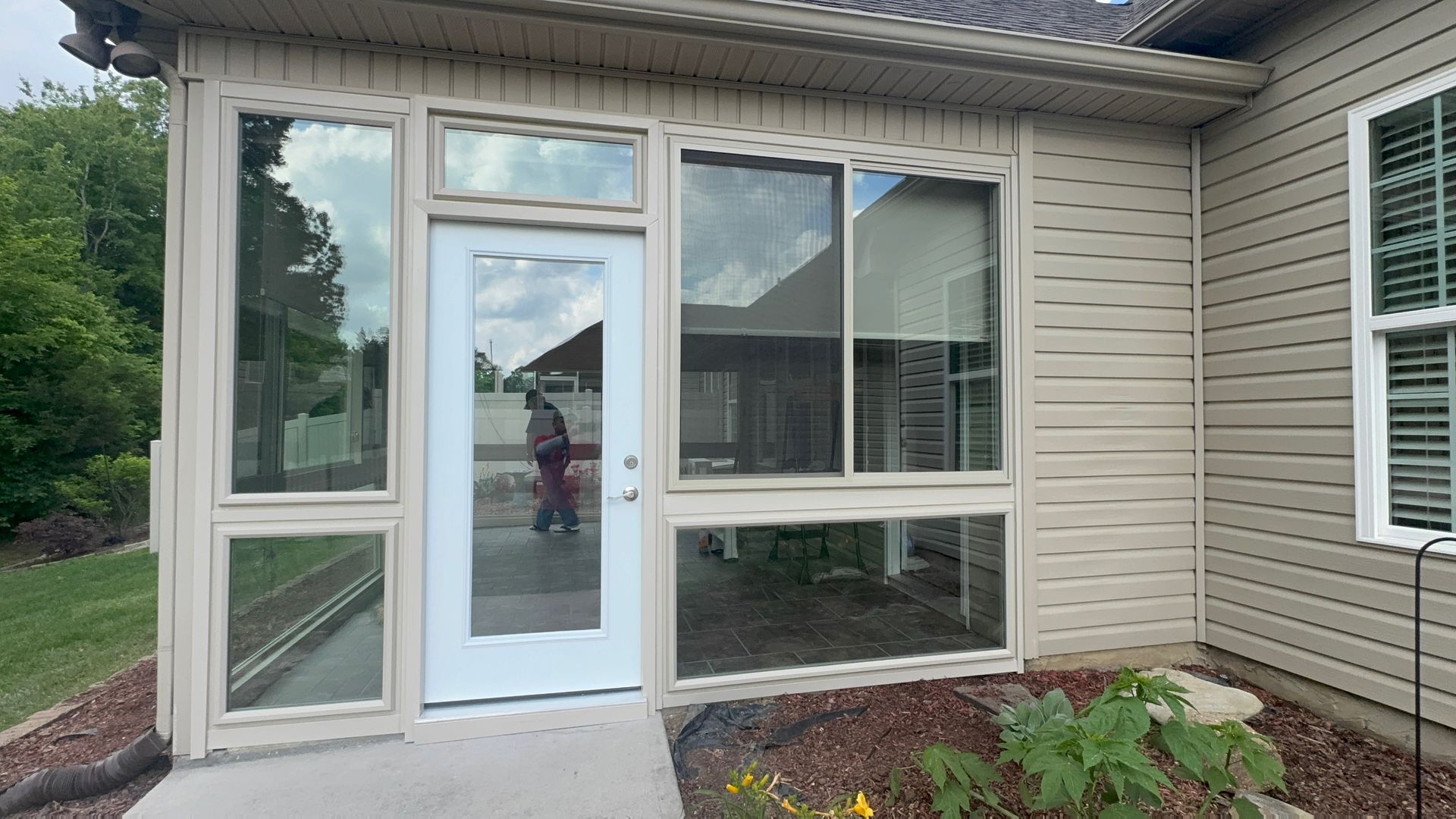A house with a screened in porch and a white door.