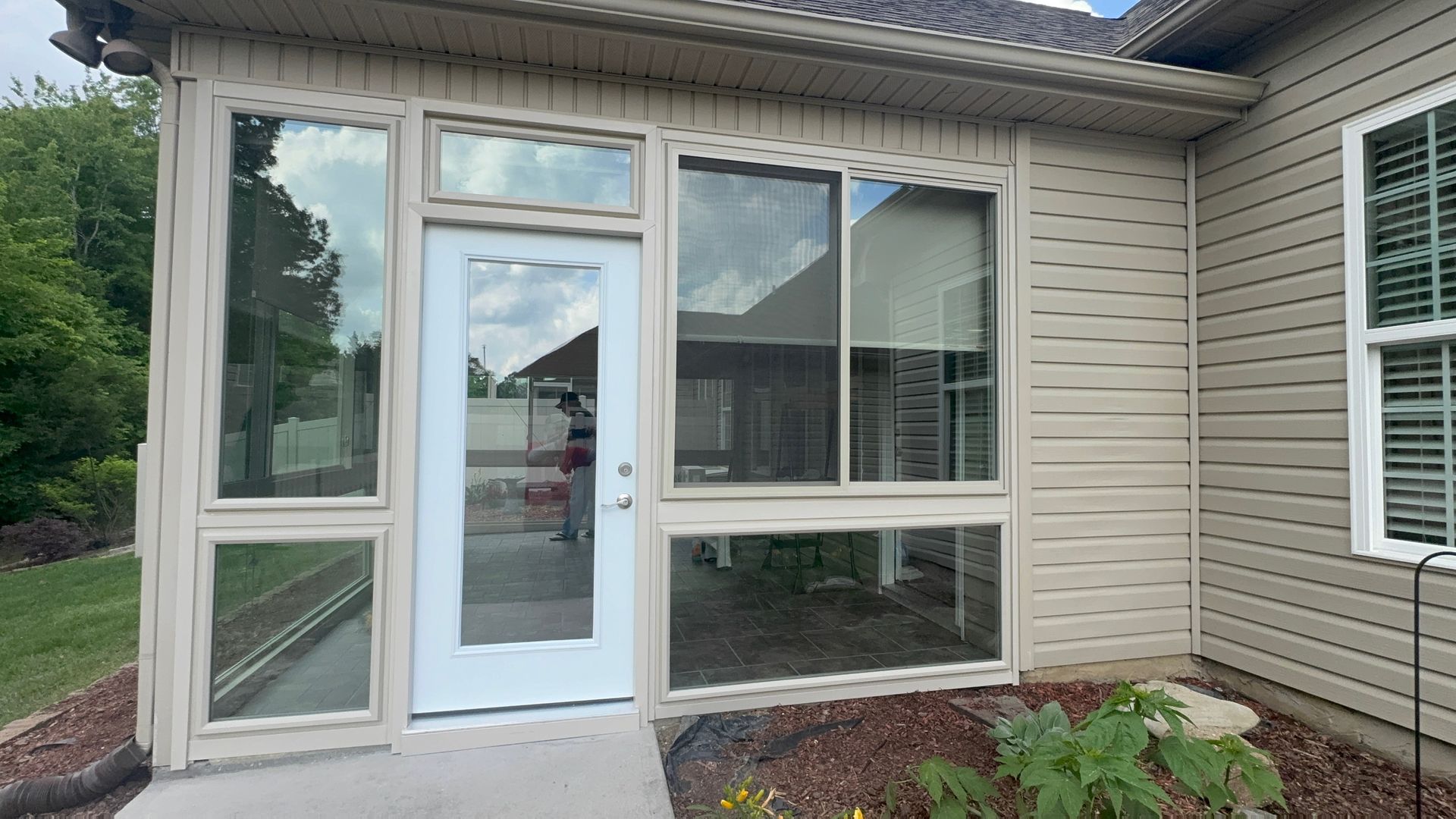 A house with a screened in porch and a white door.