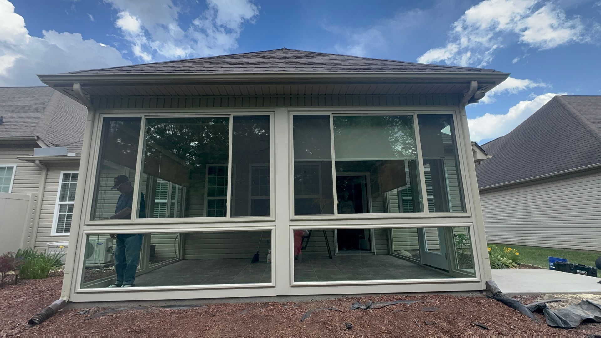 A screened in porch is being built on the side of a house.