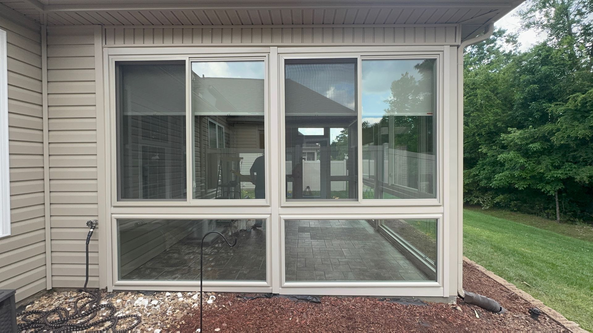 A house with a screened in porch and sliding glass doors.