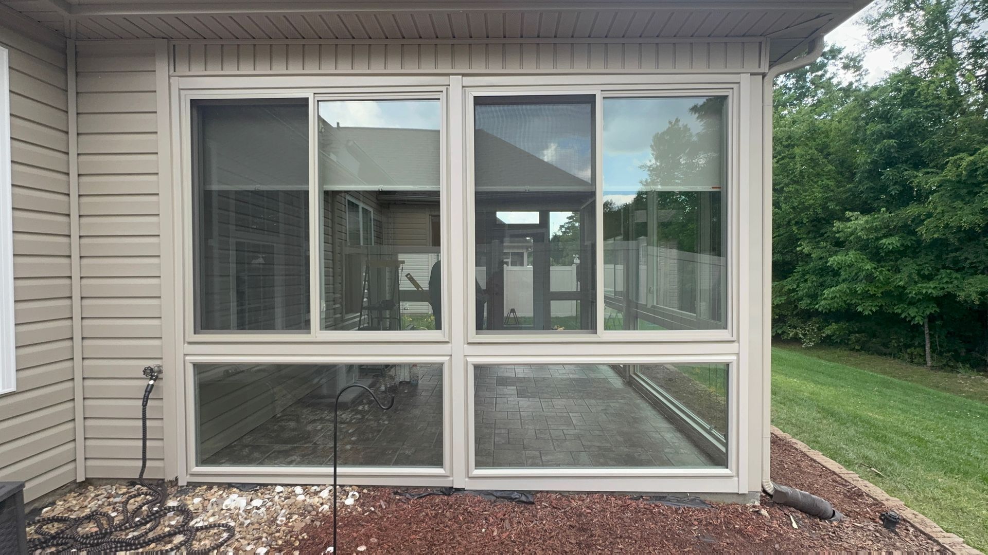 A house with a screened in porch and sliding glass doors.