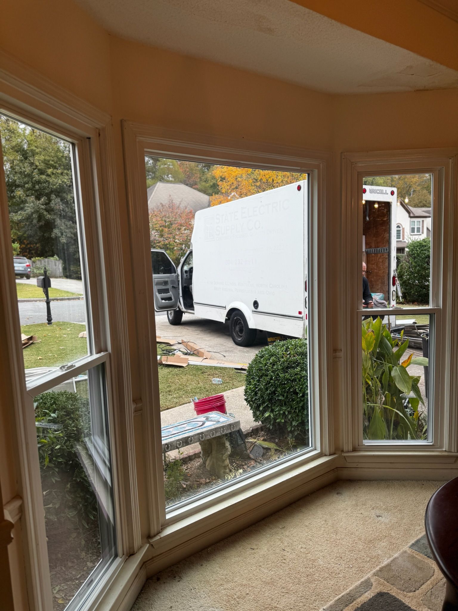 A white trailer is parked in front of a window in a living room.