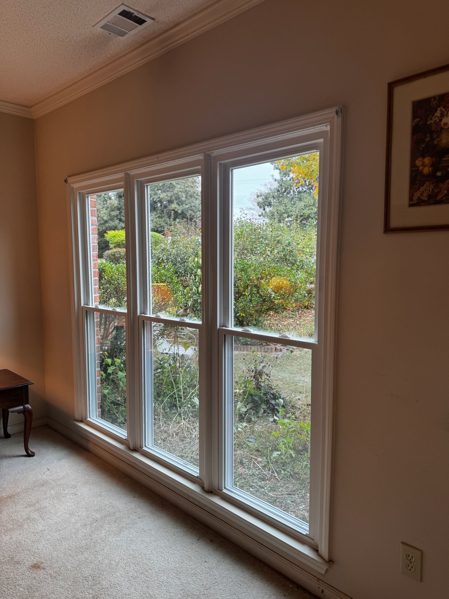 A room with a lot of windows and a picture on the wall.
