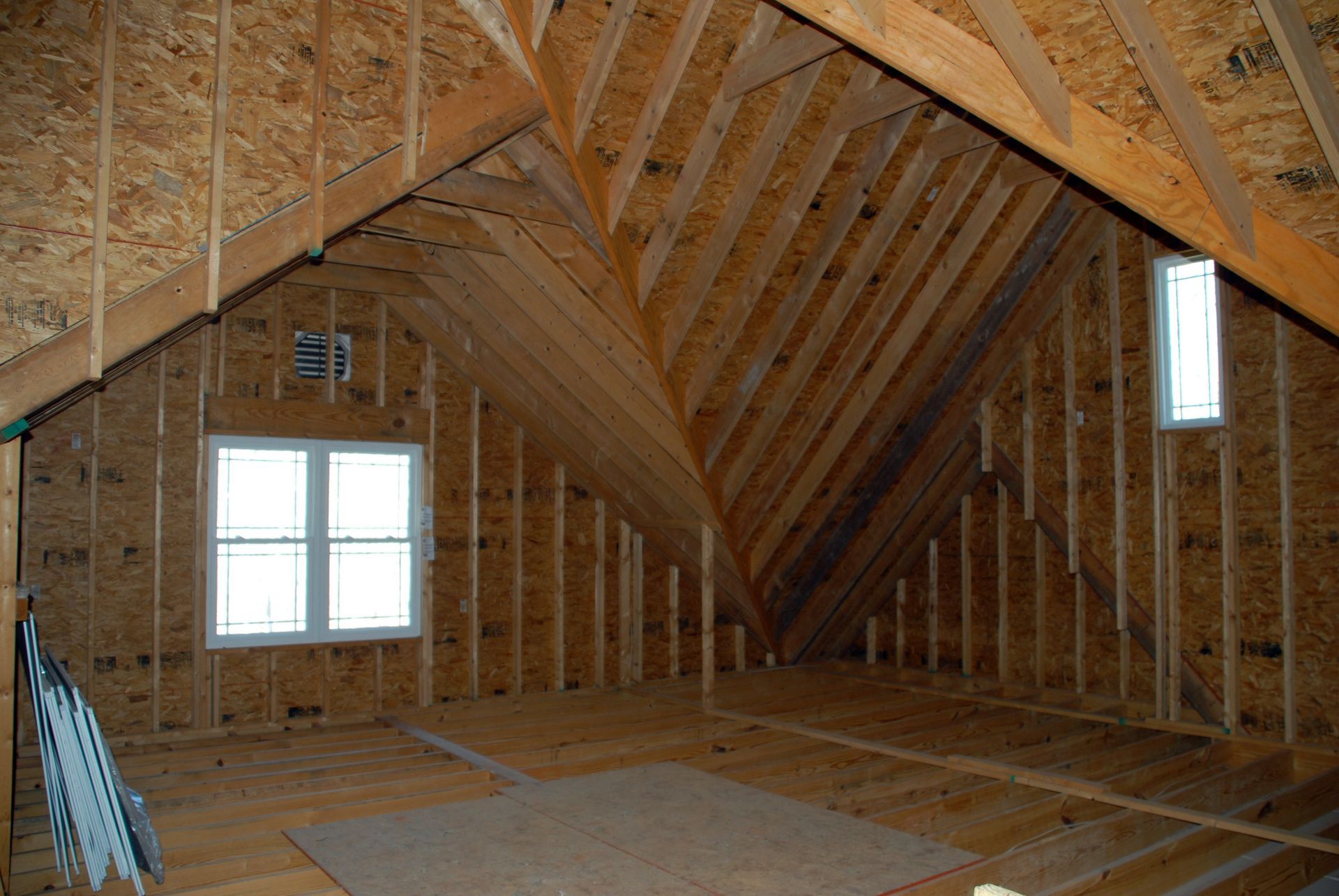 The attic of a house is being built and has a vaulted ceiling.