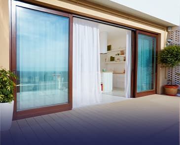 A balcony with sliding glass doors and a view of the ocean.