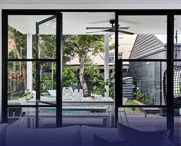 A living room with a table and chairs and a ceiling fan.