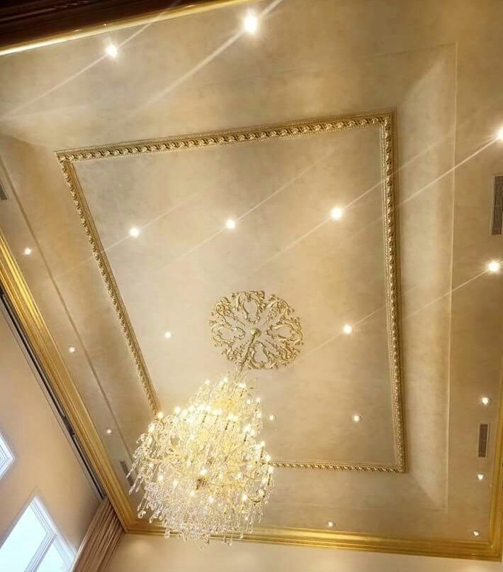 Ornate gold ceiling with chandelier and recessed lighting.