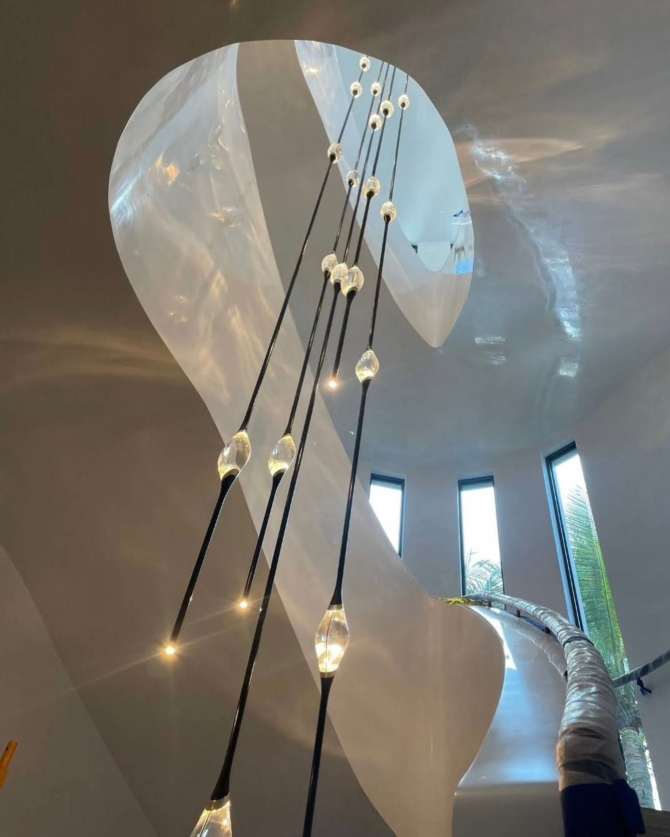 Spiral staircase with hanging lights, soft lighting and unique architecture.