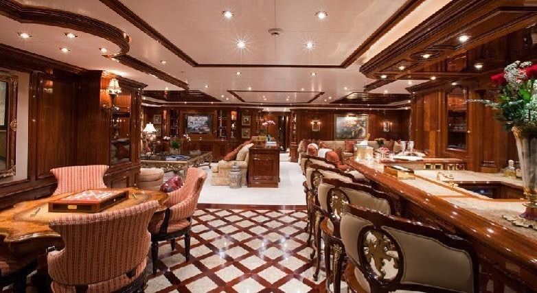 Luxurious yacht interior with a bar, seating, and wood paneling.