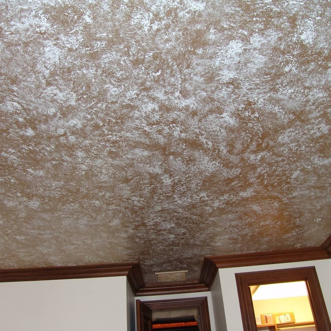 Brown and silver textured ceiling with brown trim and wood frame doorway.