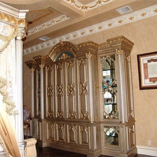 Ornate gold and silver cabinet in a room with detailed ceiling and wall decor.