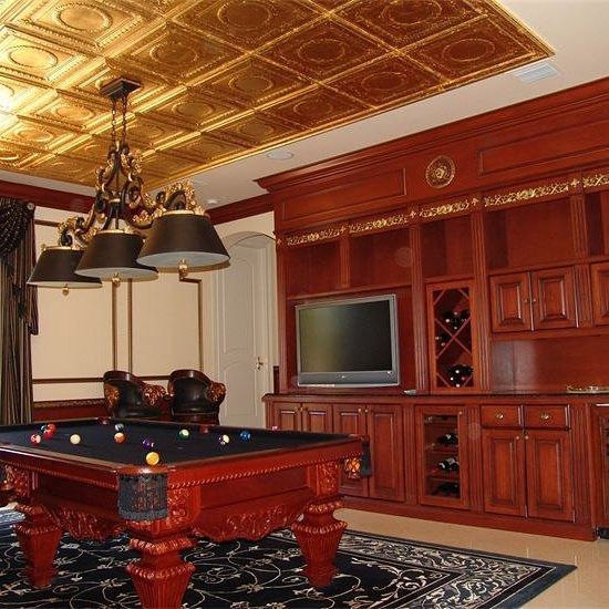 Pool room with a red pool table, dark wood built-ins, gold ceiling, and a chandelier.