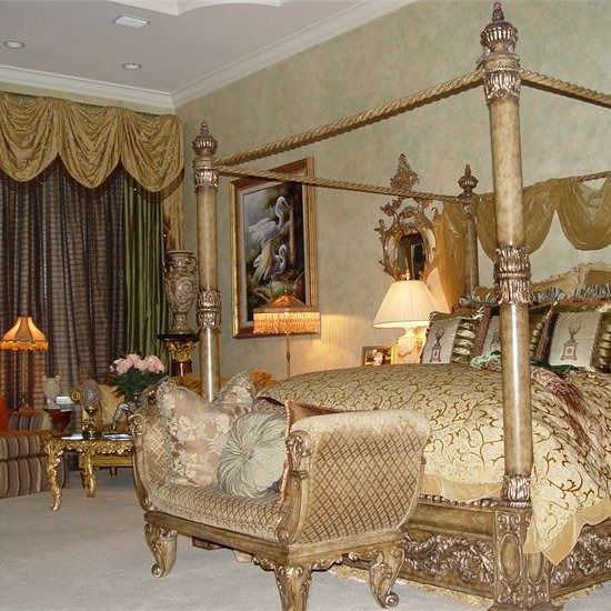 Ornate bedroom with canopy bed, gold and beige decor, and a decorative loveseat.