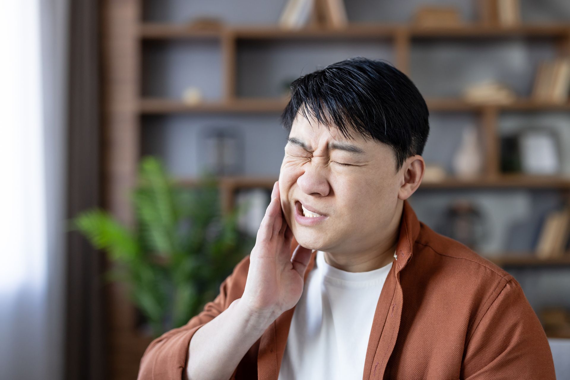 Man with toothache needing emergency dental care to relieve severe jaw pain and facial swelling.