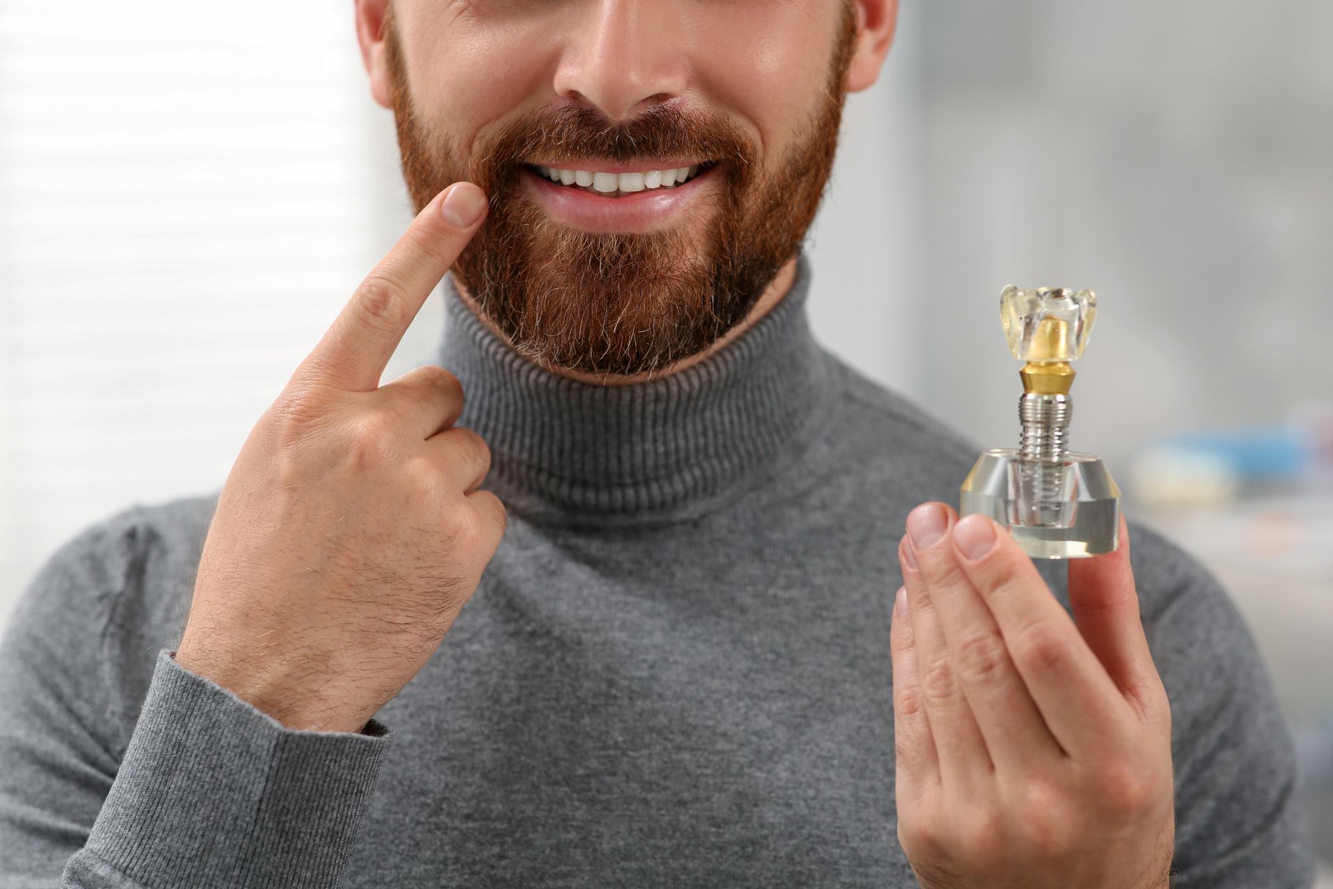 Close-up of a patient holding a model of dental implants to show successful tooth restoration. Close-up of a patient holding a model of dental implants to show successful tooth restoration.