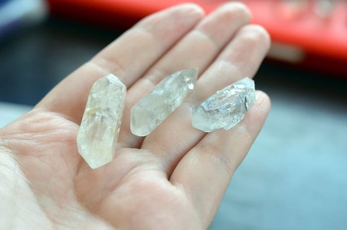 A person is holding three Quartz in their hand.