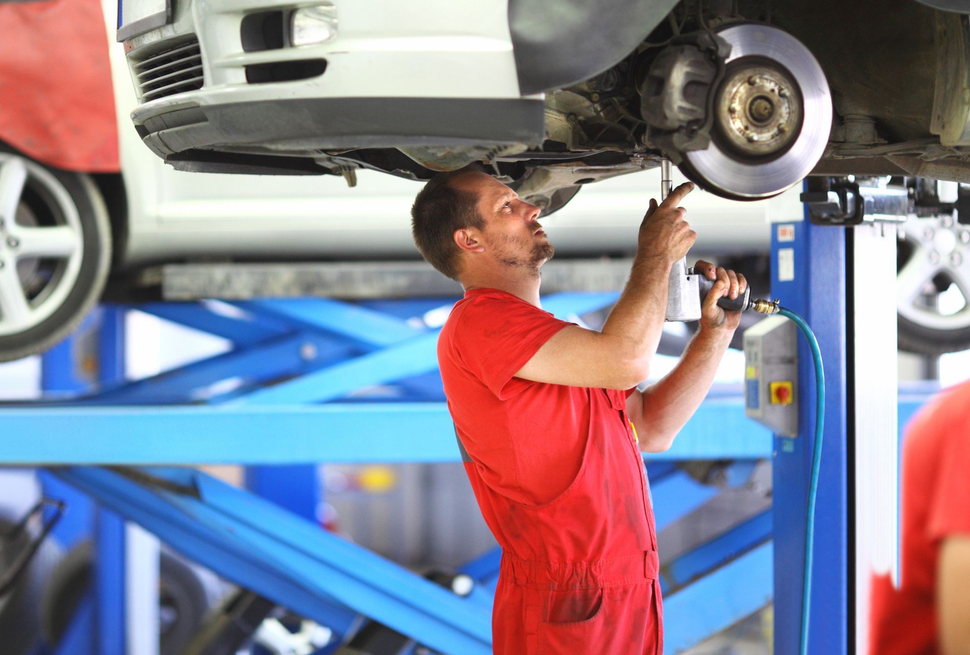 A mechanic is replacing the brake system on a vehicle.