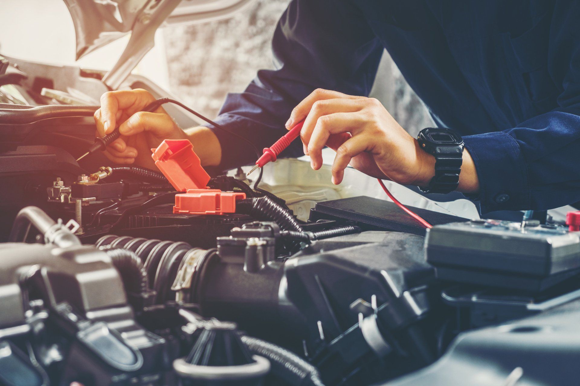 A mechanic checking a car’s battery at an auto repair shop near Spring Valley, CA
