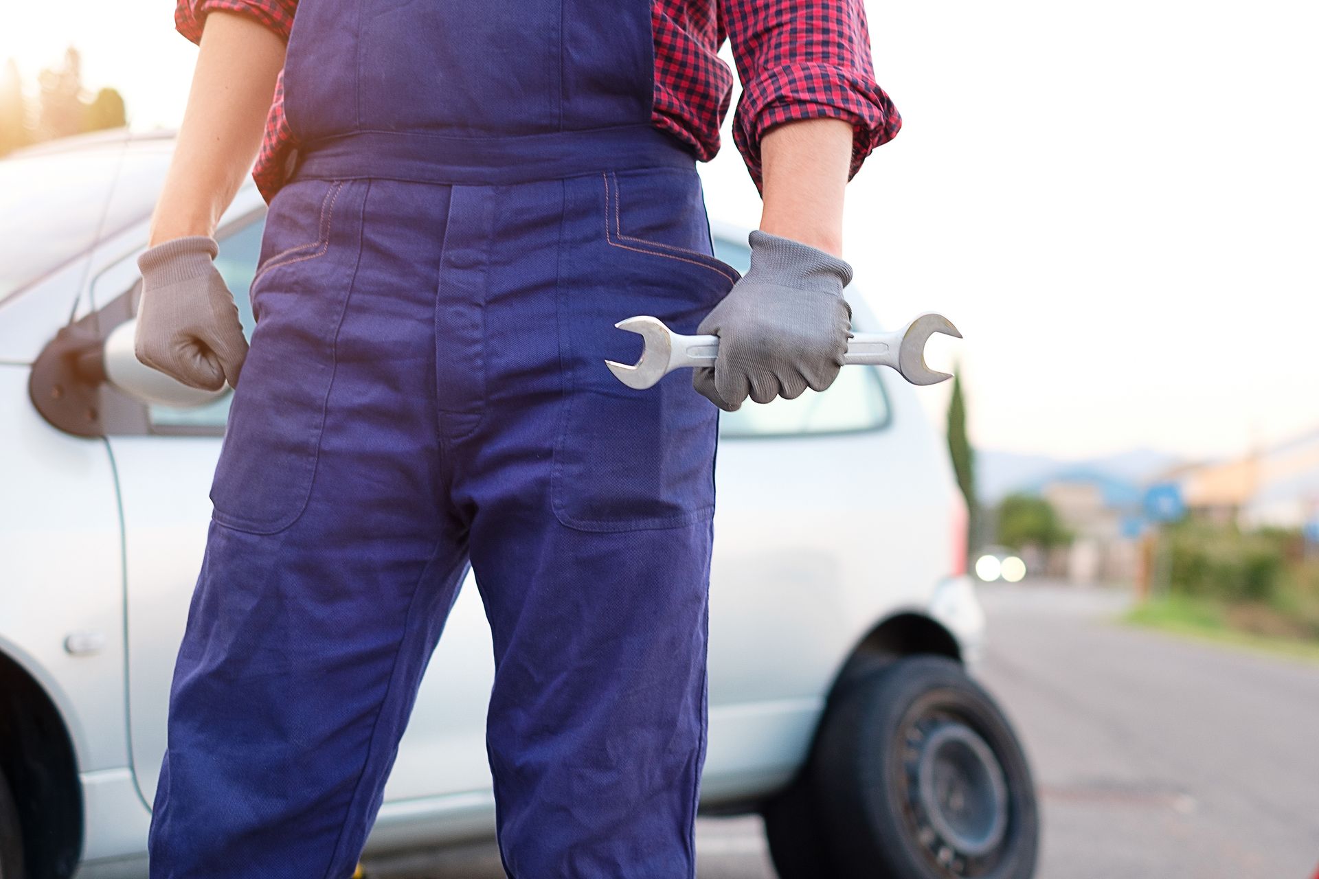 A person in overalls holding a wrench