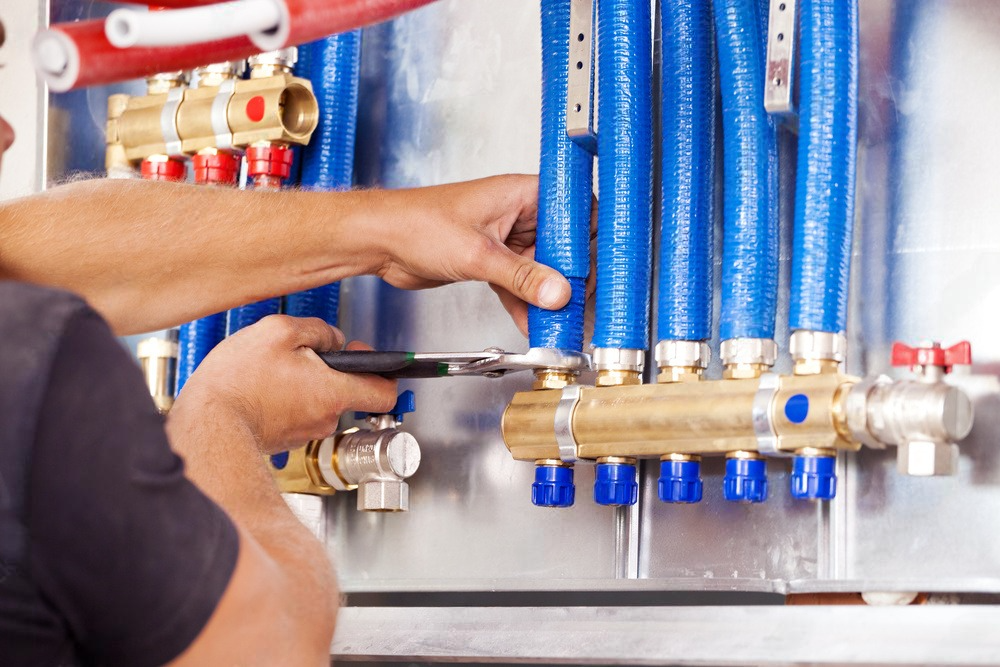 Plumber installs central heating distributor with precision.