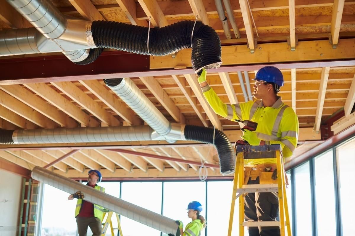 a group of construction workers are working on the ceiling of a building .