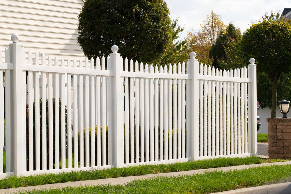 a white picket fence surrounds a lush green yard