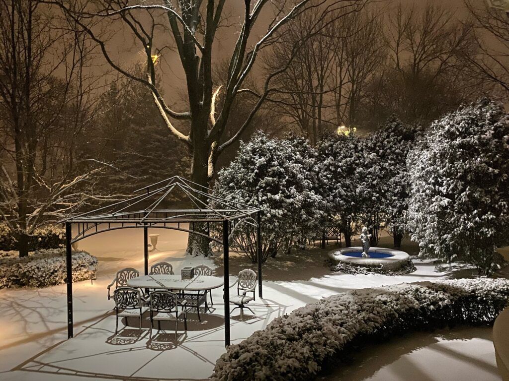 A gazebo with a table and chairs in the snow