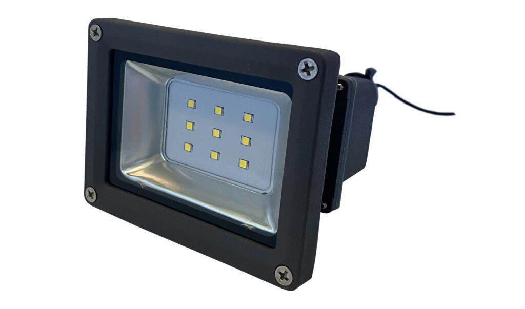 A black flood light with a cord attached to it on a white background.