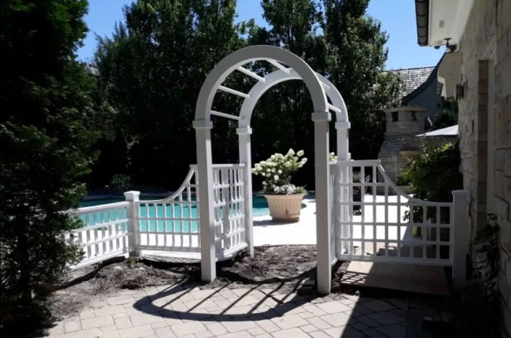 A white archway leads to a swimming pool