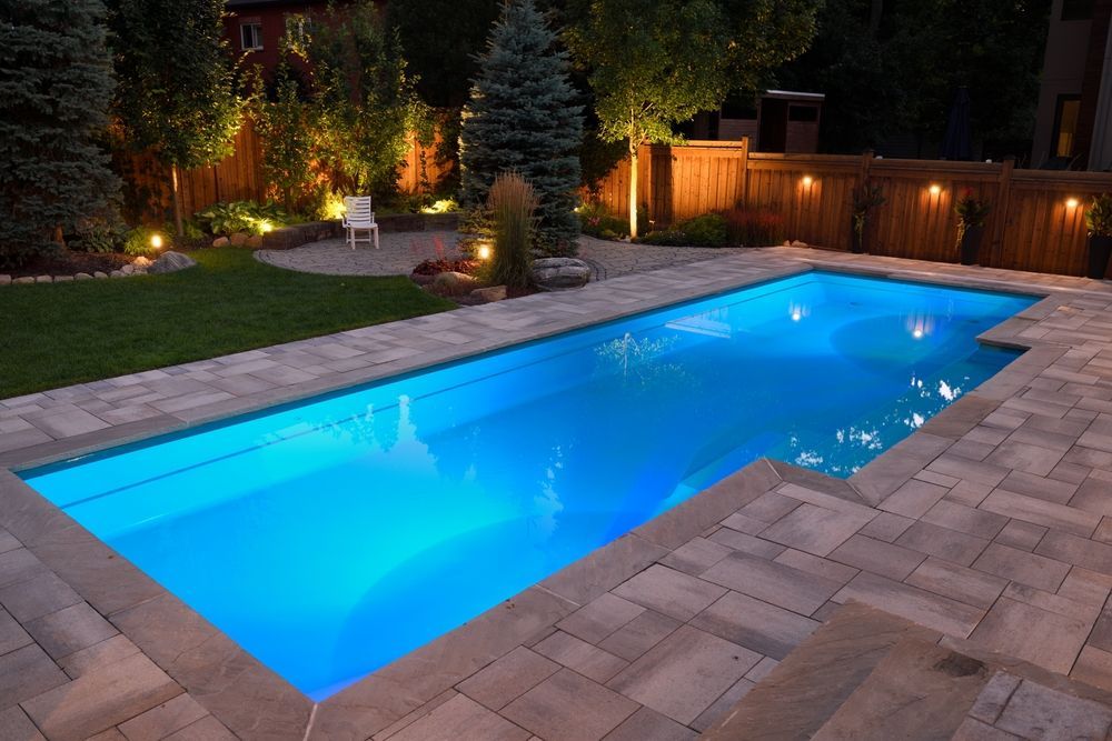 A large swimming pool is lit up at night