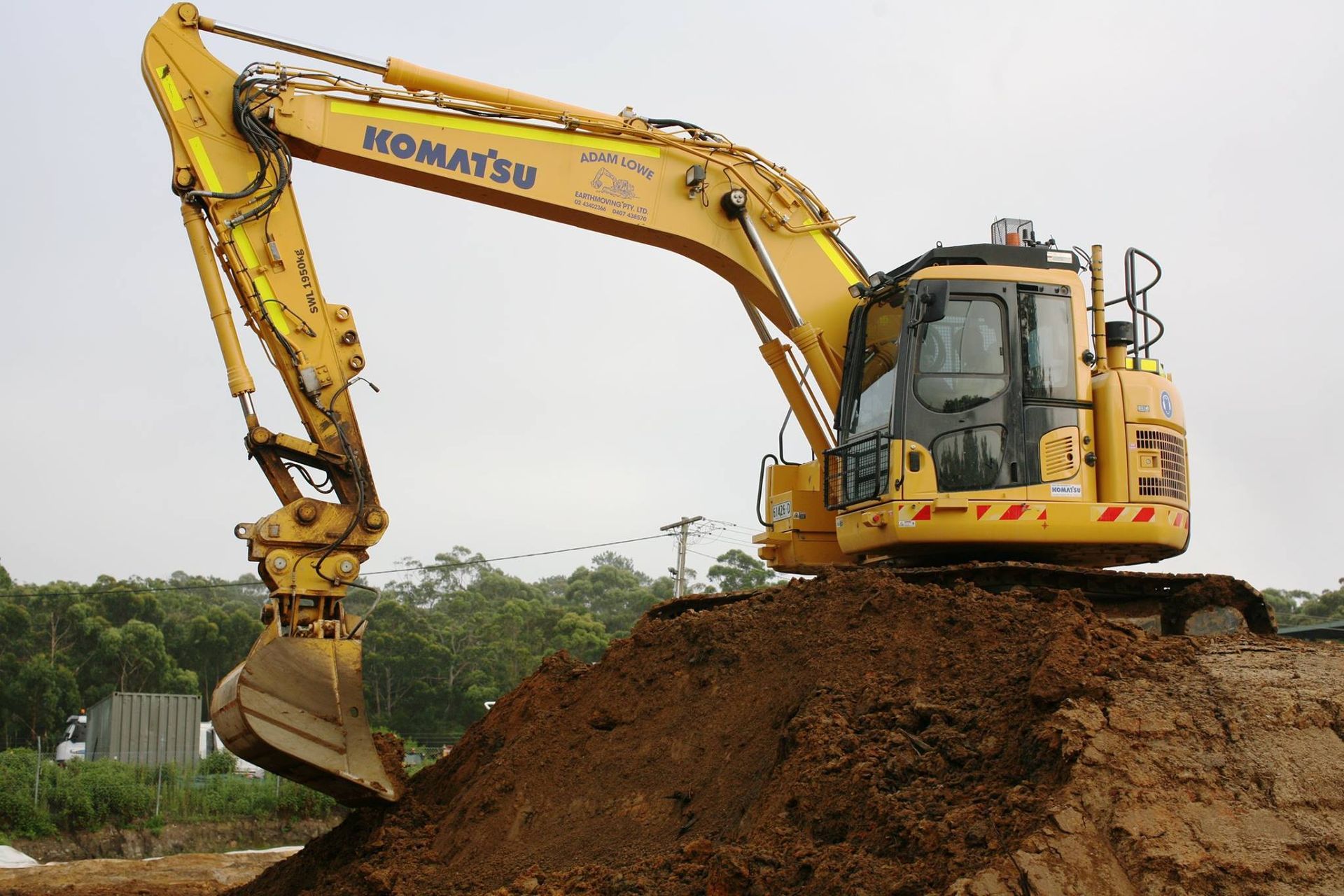 A Yellow Dump Truck Is Parked on A Sandy Beach — Adam Lowe Earthmoving Pty Ltd in Somersby, NSW