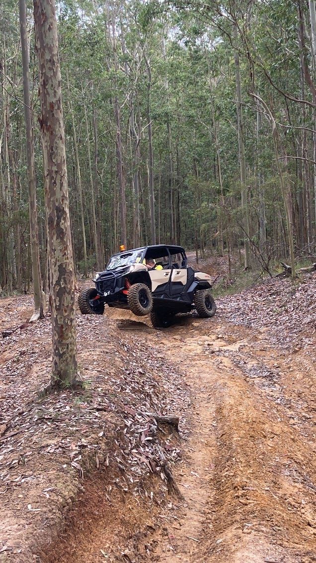A jeep is driving down a dirt road in the woods. — Adam Lowe Earthmoving Pty Ltd in Somersby, NSW
