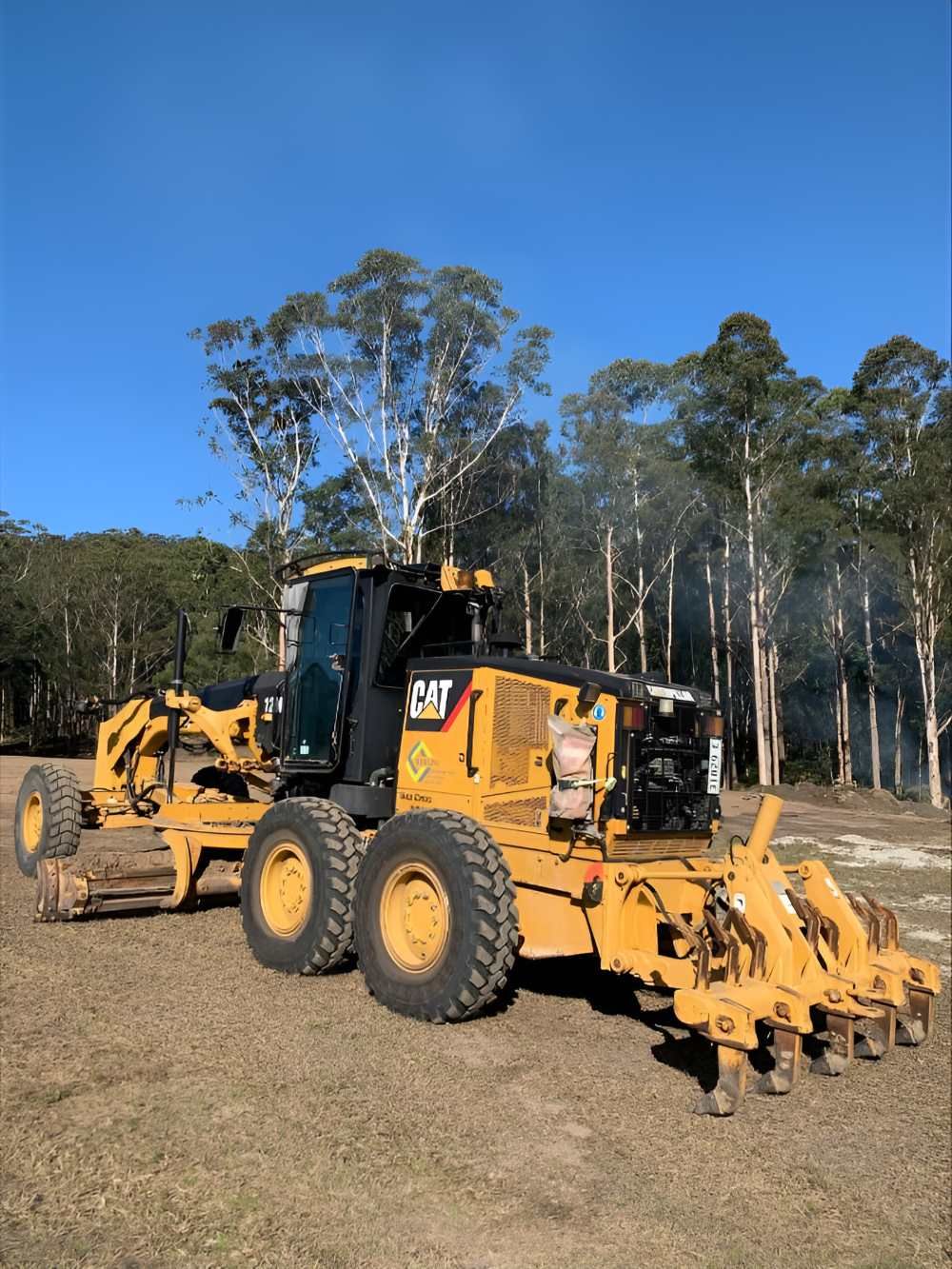 A Couple of Yellow Tractors Are Parked in A Field — Adam Lowe Earthmoving Pty Ltd in Somersby, NSW