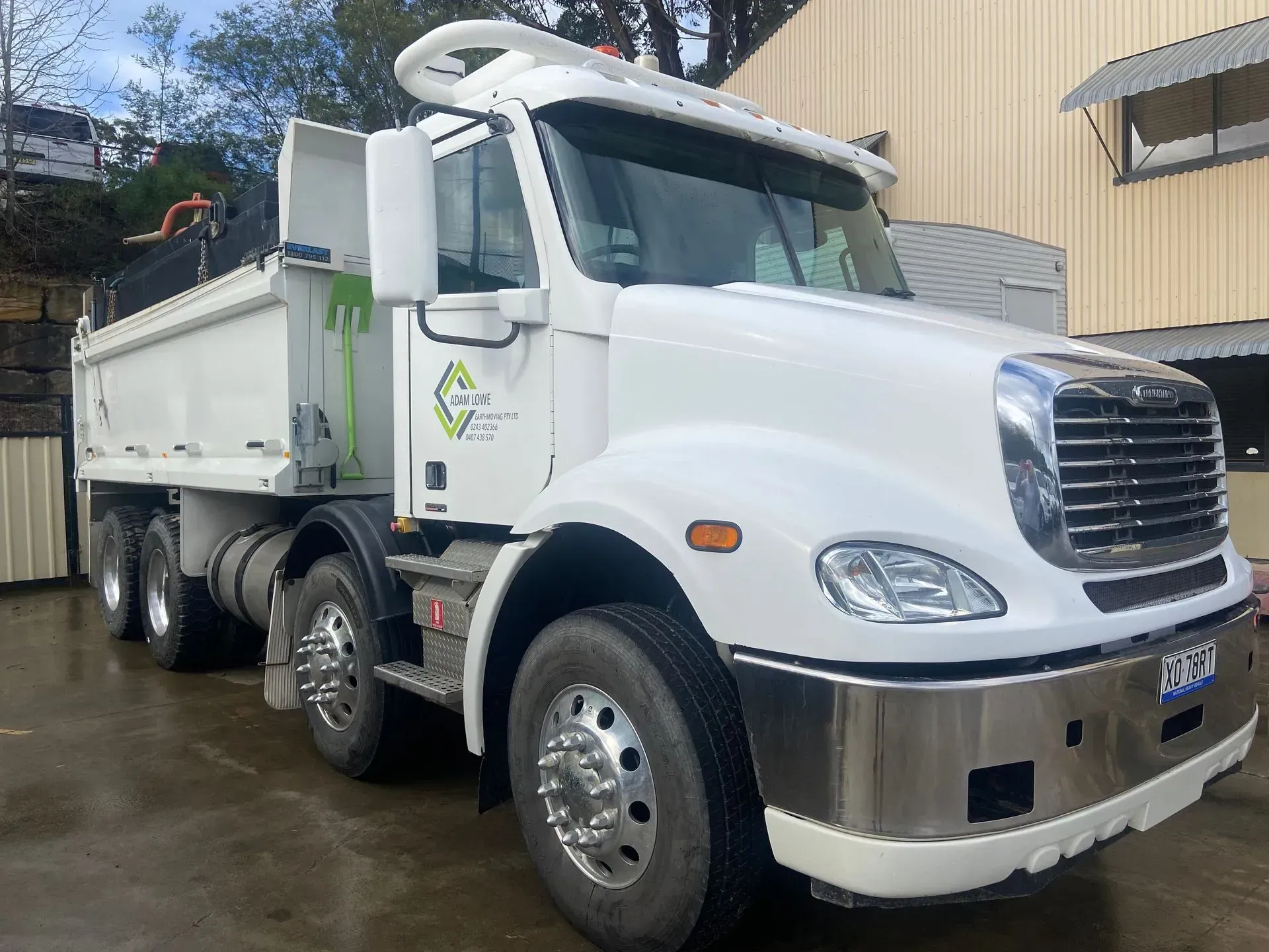 A Truck with A Crane Attached to It Is Carrying Logs — Adam Lowe Earthmoving Pty Ltd in Somersby, NSW
