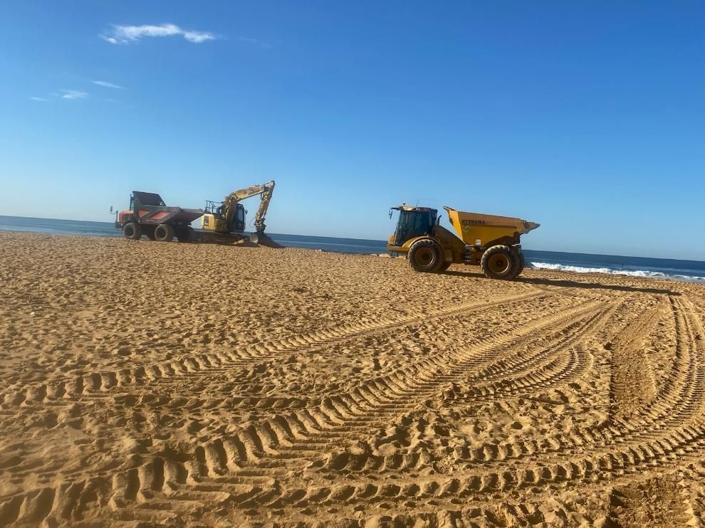 A Dump Truck Is Driving on A Sandy Beach — Adam Lowe Earthmoving Pty Ltd in Somersby, NSW