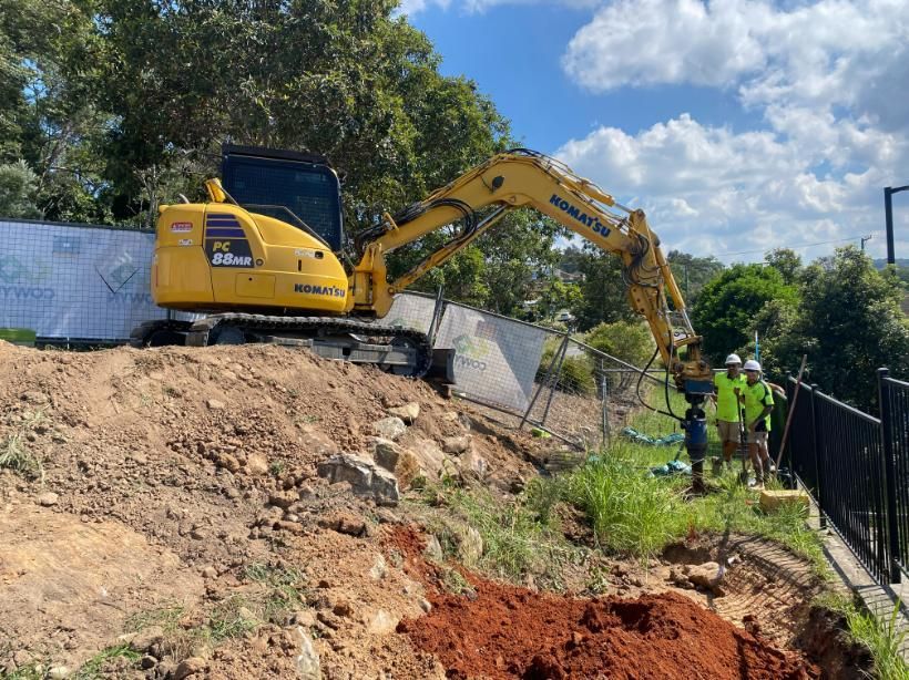 A Yellow Excavator Is Sitting on Top of A Pile of Dirt — Adam Lowe Earthmoving Pty Ltd in Somersby, NSW