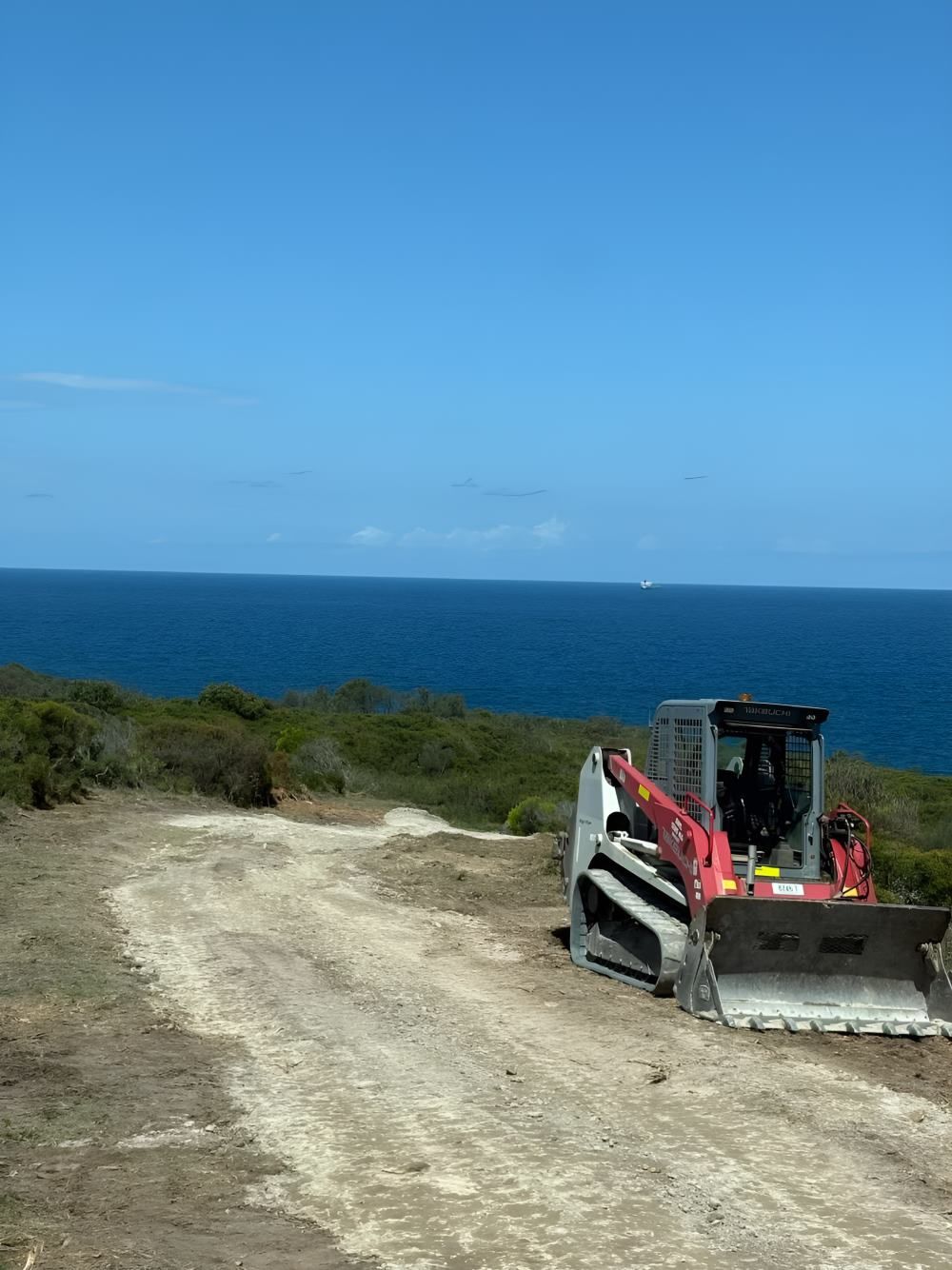 A Bulldozer Is Parked on A Dirt Road — Adam Lowe Earthmoving Pty Ltd in Somersby, NSW