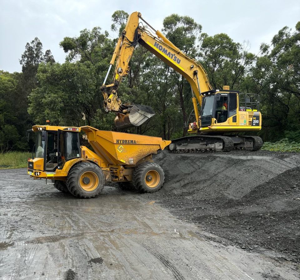 A dump truck and a excavator on a job site — Adam Lowe Earthmoving Pty Ltd in Somersby, NSW